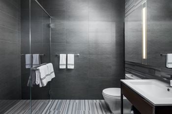 A bathroom with a toilet, sink, and shower.
