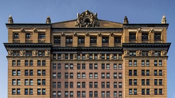 A large building with a statue at one west,new york, ny