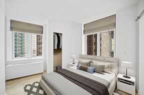 New York apartment for rent - A bedroom with a large bed and a window with a view of a city at Aria, New York