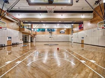 A basketball court in the middle of a gym with a ball on it