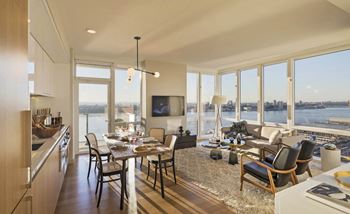 A rendering of a living room and dining room with a view of the water
