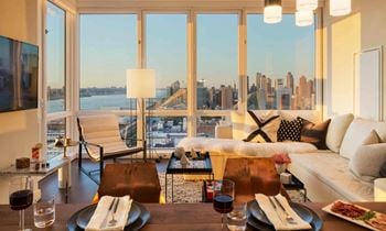 A view of the city from a living room with a couch and a table