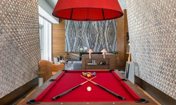 A pool table in a living room with a red pool