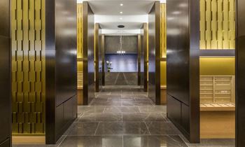 A row of elevators in a hotel lobby with gold doors