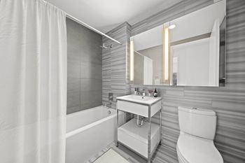 A bathroom with a tub and a sink and a mirror