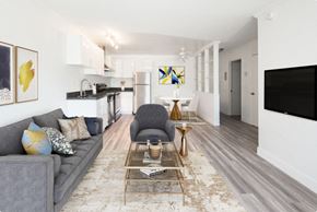 San Leandro apartment for rent - Living room furnished with grey couch TV. Kitchen on the background