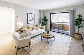 San Lorenzo apartment for rent - A living room with a white sofa, a white armchair, a coffee table, and a large window with a view of the outside.