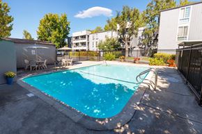 Concord apartment for rent - A small pool surrounded by a fence and trees.