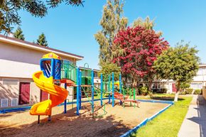 Hayward apartment for rent - A playground with a yellow slide and a red bench.