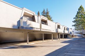 Concord apartment for rent - A long row of white buildings with a clear blue sky above.