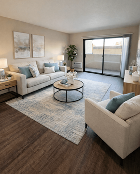 Concord apartment for rent - A living room with a grey couch, a coffee table, and a plant.