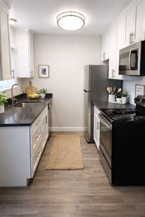Livermore apartment for rent - A kitchen with black countertops and white cabinets.