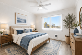 Hayward apartment for rent - A bedroom with a bed, nightstand, and a plant.