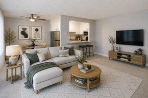 Livermore apartment for rent - A living room with a white couch, a wooden coffee table, and a flat-screen TV mounted on the wall.