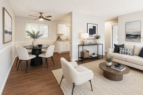 Concord apartment for rent - A living room with a white couch, a black table, and a ceiling fan.