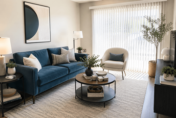 San Leandro apartment for rent - A living room with a blue couch, a white chair, and a coffee table with decorative items on it.