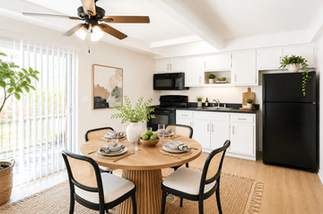 San Leandro apartment for rent - A black refrigerator is in a kitchen with a table and chairs.
