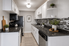 Hayward apartment for rent - A kitchen with black countertops and white cabinets.