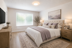 San Leandro apartment for rent - A bedroom with a large bed, a wooden dresser, and a painting on the wall.