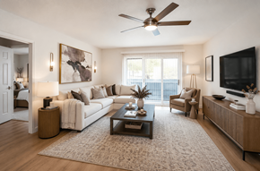 Concord apartment for rent - A living room with a white couch, a coffee table, and a ceiling fan.