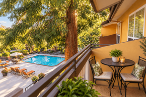 Fremont apartment for rent - A patio with a table and chairs overlooking a pool.