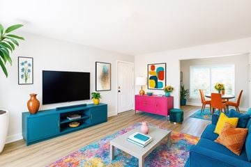 San Jose apartment for rent - A living room with a blue couch and a television on a cabinet.