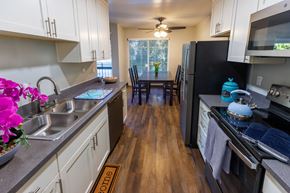 Fremont apartment for rent - A kitchen with a black fridge and wooden floors.