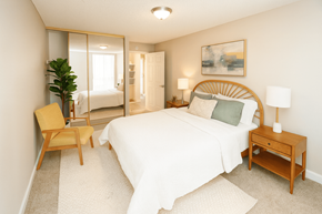 Concord apartment for rent - A bedroom with a large bed, a chair, and a painting on the wall.