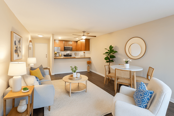 Concord apartment for rent - A living room with a white couch, a coffee table, and a dining table with chairs.