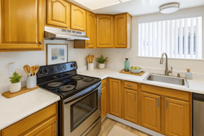 Concord apartment for rent - A kitchen with wooden cabinets and a black stove top oven.