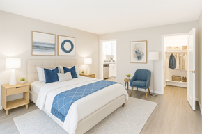 Concord apartment for rent - A bedroom with a large bed and a blue chair.