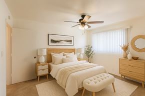 San Leandro apartment for rent - A bedroom with a bed, nightstand, and chair.
