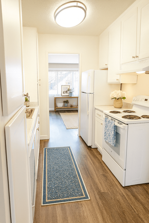 Walnut Creek apartment for rent - A kitchen with white appliances and a blue rug on the floor.