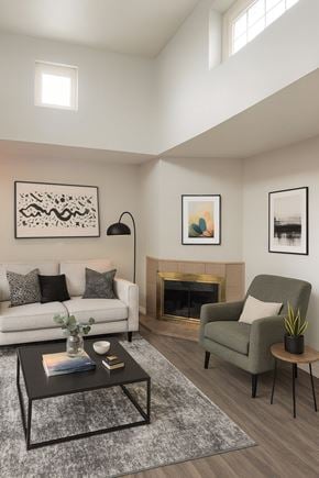 Concord apartment for rent - A living room with a white couch, a green armchair, a coffee table, and a fireplace.