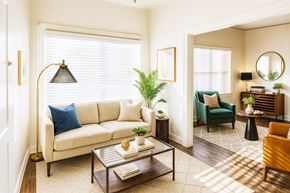 Alameda apartment for rent - A living room with a white sofa, a green armchair, a coffee table, and a lamp.