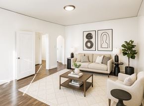 Alameda apartment for rent - A living room with a white couch, a coffee table, and a plant.
