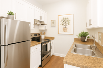 Fremont apartment for rent - A kitchen with a stainless steel refrigerator and white cabinets.