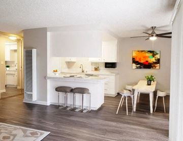 Concord apartment for rent - A kitchen with white cabinets and a bar area with stools.