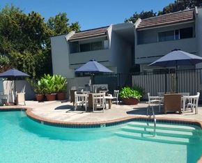 Concord apartment for rent - a swimming pool with tables and umbrellas in front of a house