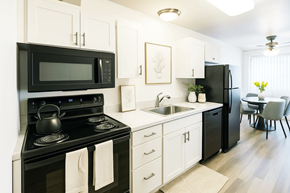 San Leandro apartment for rent - A black and white kitchen with a stove, microwave, and refrigerator.
