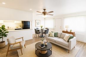 San Leandro apartment for rent - A living room with a couch, chairs, and a dining table.