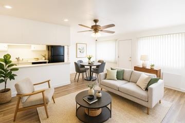 San Leandro apartment for rent - A living room with a couch, chairs, and a dining table.