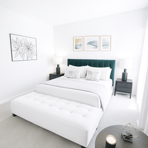 Concord apartment for rent - A white bed with a green headboard is in a room with a white wall and a black and white picture.