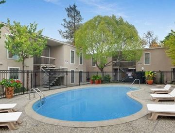 Concord apartment for rent - A swimming pool surrounded by lounge chairs and trees.