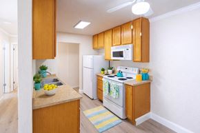 San Leandro apartment for rent - A kitchen with wooden cabinets and white appliances.