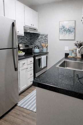 Fremont apartment for rent - A modern kitchen with a black countertop and stainless steel appliances.