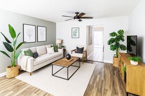Hayward apartment for rent - A living room with a white couch, a wooden coffee table, and a ceiling fan.
