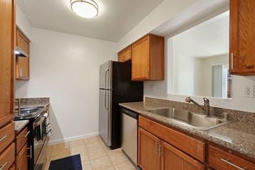 Fairfield apartment for rent - A kitchen with a black refrigerator and wooden cabinets.