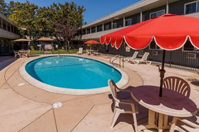 Concord apartment for rent - A pool with a table and chairs and umbrellas.