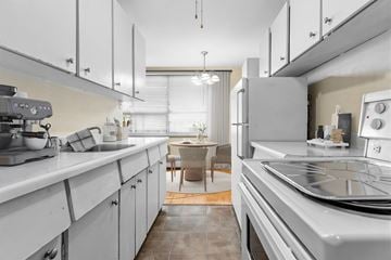 Etobicoke apartment for rent - A modern kitchen with white cabinets and stainless steel appliances.